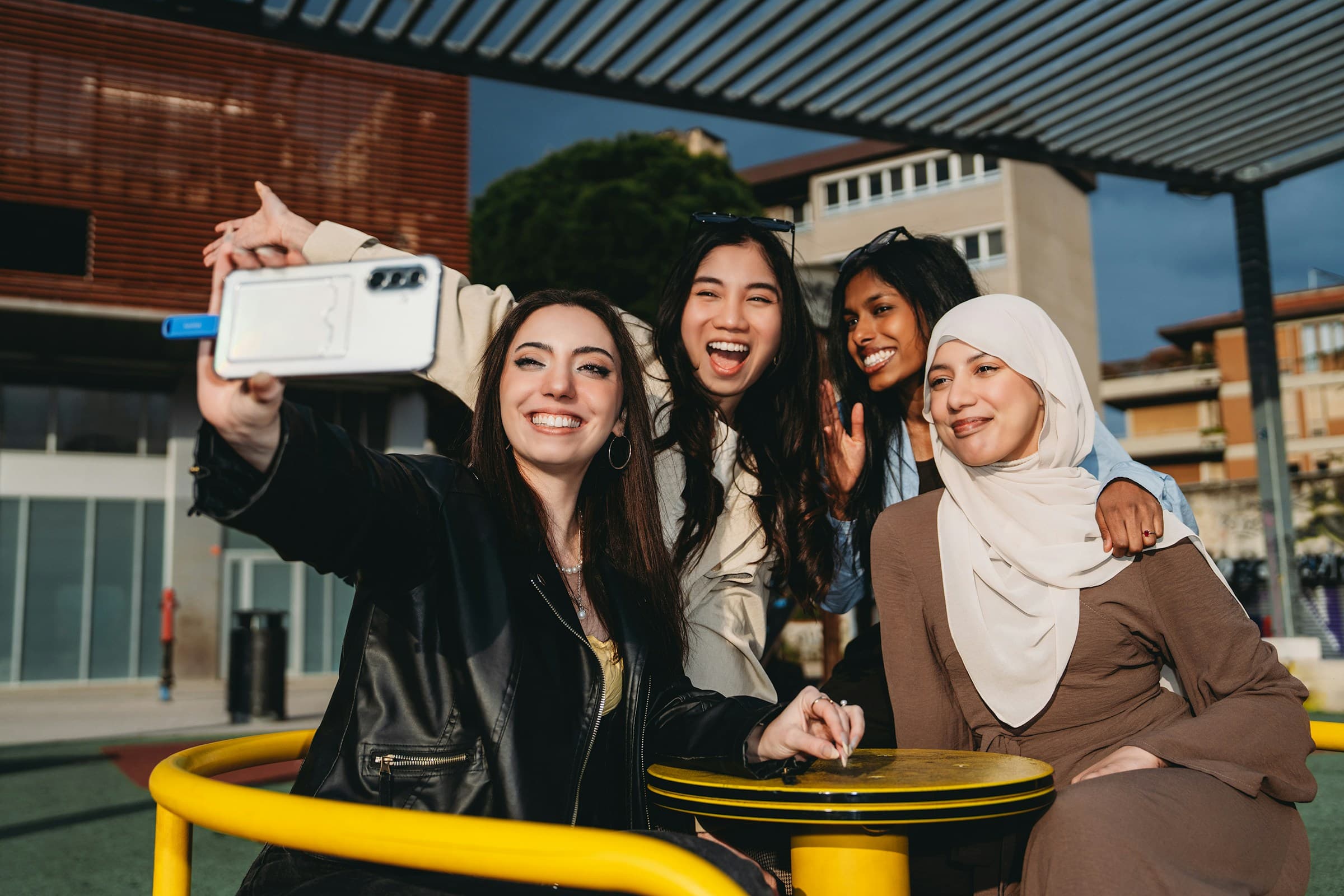 A diverse group of young women sharing a joyful moment outdoors